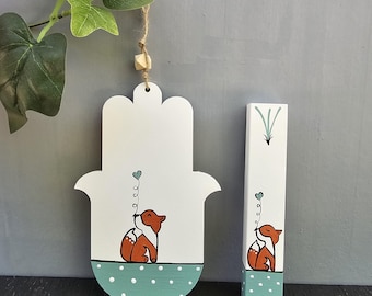 Pode incluir: Decorações de madeira: uma mão de Hamsa branca e um retângulo. A mão de Hamsa tem uma base de bolinhas turquesa e uma raposa com um balão em forma de coração. O retângulo apresenta uma raposa e uma ilustração de planta.