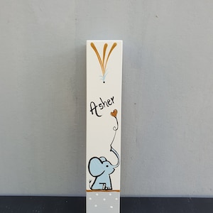 Hand painted elephant mezuzah case for boys nursery on white wood with soft blue illustration and gold accents. Personalized Jewish mezuzah for baby room, kids room decor and meaningful newborn gift with custom name in Hebrew or English.