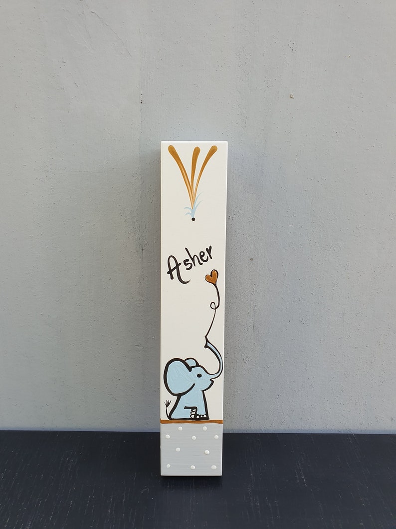 Hand painted elephant mezuzah case for boys nursery on white wood with soft blue illustration and gold accents. Personalized Jewish mezuzah for baby room, kids room decor and meaningful newborn gift with custom name in Hebrew or English.