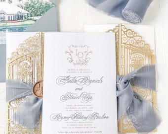May include: A wedding invitation with a gold and white design. The invitation features a gold gate design with a blue ribbon and a wax seal. The text on the invitation reads "The union of their families is celebrated at the wedding of Talia Daniels and Vincel Alfa Thursday the second of January two thousand twenty three at five thirty in the morning Disney Wedding Pavilion followed by a bridal reception at Whitehall Farm and Patio 123 Grand European Resort and Spa 12345 Main Street, Anytown, USA "As in love, so in life, it is what makes life divine." - Cinderella