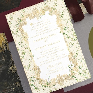 May include: Wedding invitation with a cream background, gold filigree frame, and green vine accents. The invitation includes the names Gabrielle Noel and Gilbert Soriano, along with event details. Additional burgundy envelopes and ribbon are visible.