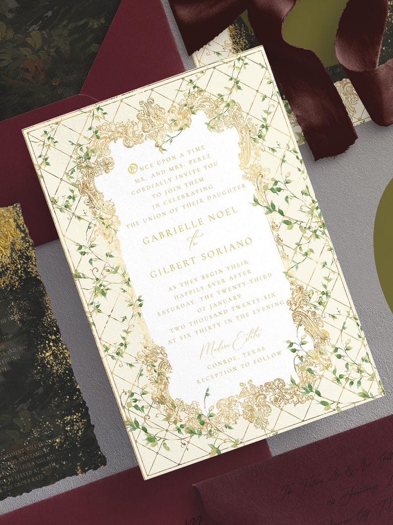May include: Wedding invitation with a cream background, gold filigree frame, and green vine accents. The invitation includes the names Gabrielle Noel and Gilbert Soriano, along with event details. Additional burgundy envelopes and ribbon are visible.
