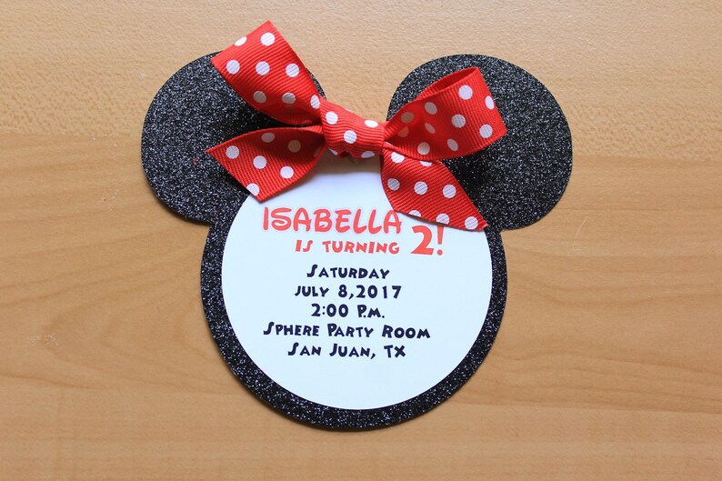 May include: A Minnie Mouse-shaped birthday invitation with a red and white polka dot bow. The invitation includes the text "ISABELLA IS TURNING 2!" and event details: Saturday, July 8, 2017, 2:00 P.M., Sphere Party Room, San Juan, TX.