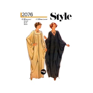 May include: A vintage sewing pattern for a long, flowing dress. The pattern is for a size small, 8-10, and is called "Style" 2076. The pattern shows two women wearing the dress, one in a light beige colour and the other in a dark blue colour.