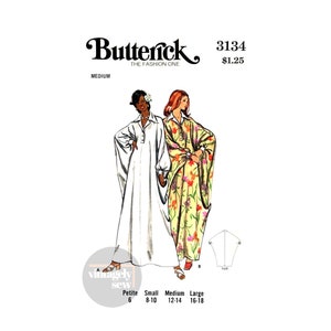 Op de afbeelding: Een vintage naaipatroon voor een lange, vloeiende jurk. Het patroon is voor maten 6-18 en bevat twee verschillende stijlen: een witte jurk met lange mouwen en een jurk met bloemenprint met korte mouwen. Het patroon is van Butterick, The Fashion One, en heeft nummer 3134.