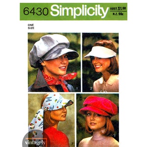 May include: Simplicity sewing pattern number 6430 for a one-size hat. The pattern includes four different hat styles: a grey newsboy cap, a white visor, a blue and white patterned visor, and a red newsboy cap.