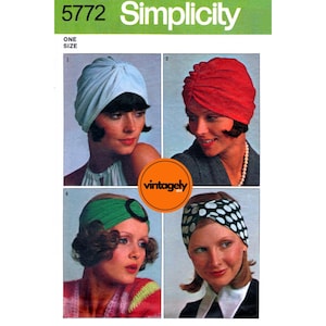 May include: Simplicity pattern 5772 featuring four headwear styles: a light blue turban, a red turban, a green headband with a black circle, and a black and white polka dot headband. The word "Simplicity" is in green.