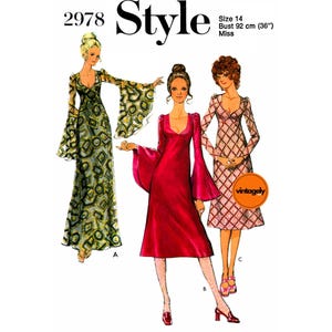May include: Vintage dressmaking pattern with three dress designs. The pattern is size 14, with a bust measurement of 92 cm (36"). The dresses have long sleeves and a V-neck. One dress is red, another is patterned with green and yellow, and the third is pink.
