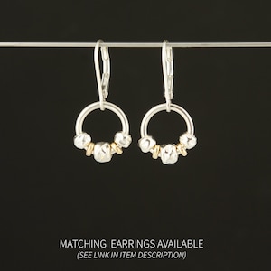 Puede incluir: Un par de pendientes con cierre de palanca y dise&ntilde;o de aro circular. Cada aro est&aacute; adornado con tres peque&ntilde;as cuentas plateadas texturizadas y dos cuentas espaciadoras doradas lisas. El texto inferior dice: MATCHING EARRINGS AVAILABLE (SEE LINK IN ITEM DESCRIPTION).