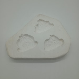 Peut inclure: Moule en céramique blanche avec trois empreintes de fleurs. Le moule est en forme de larme.