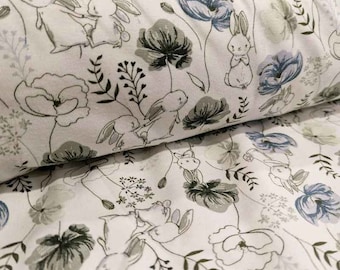May include: White fabric with a repeating pattern of bunnies, flowers, and leaves. The bunnies are in various poses, some are holding hands. The flowers are in shades of blue and gray. The leaves are in shades of green.