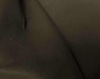 Puede incluir: Primer plano de una tela marrón oscura con una textura lisa.