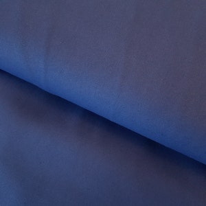 May include: A close-up of a dark blue fabric with a smooth texture.