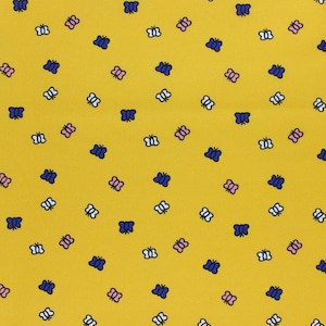 May include: A yellow fabric with a repeating pattern of blue, pink, and white butterflies.