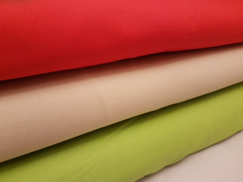 May include: Three fabric swatches in different colors: red, beige, and green. The fabric is a woven canvas material.