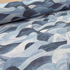 May include: Close-up of fabric with a wave-like pattern in shades of blue and white. The design features flowing lines that create a textured, three-dimensional effect. The fabric appears to be folded, adding depth to the image.