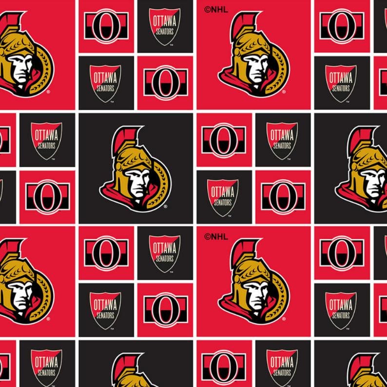 Op de afbeelding: Een rode en zwarte stof met een herhalend patroon van het logo van het NHL-hockeyteam Ottawa Senators. Het logo toont een zwarte en gouden Romeinse centurion helm met een rood en gouden schild en de woorden "Ottawa Senators".