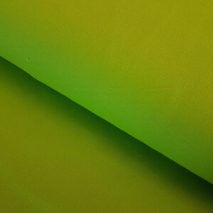 May include: A close-up of a green fabric with a gradient from a darker green to a lighter green.