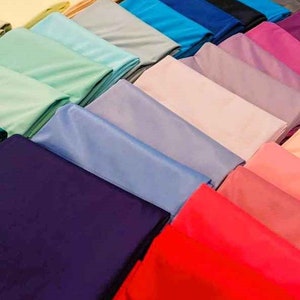 May include: A collection of fabric swatches in various colors, including light green, blue, purple, pink, red, and dark blue. The swatches are arranged in a row, with the lightest colors at the top and the darkest colors at the bottom.