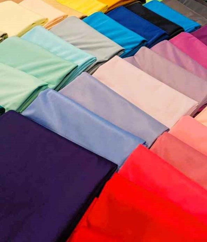 May include: A collection of fabric swatches in various colors, including light green, blue, purple, pink, red, and dark blue. The swatches are arranged in a row, with the lightest colors at the top and the darkest colors at the bottom.