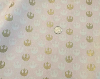 Tela de Star Wars Rebel Alliance: algodón rosa con emblema de Starbird dorado