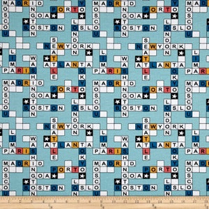 May include: Light blue fabric with a crossword puzzle design featuring city names like New York, Paris, and Madrid. The crossword squares are white with black letters, and the city names are in various colors. The fabric is suitable for quilting or crafting.
