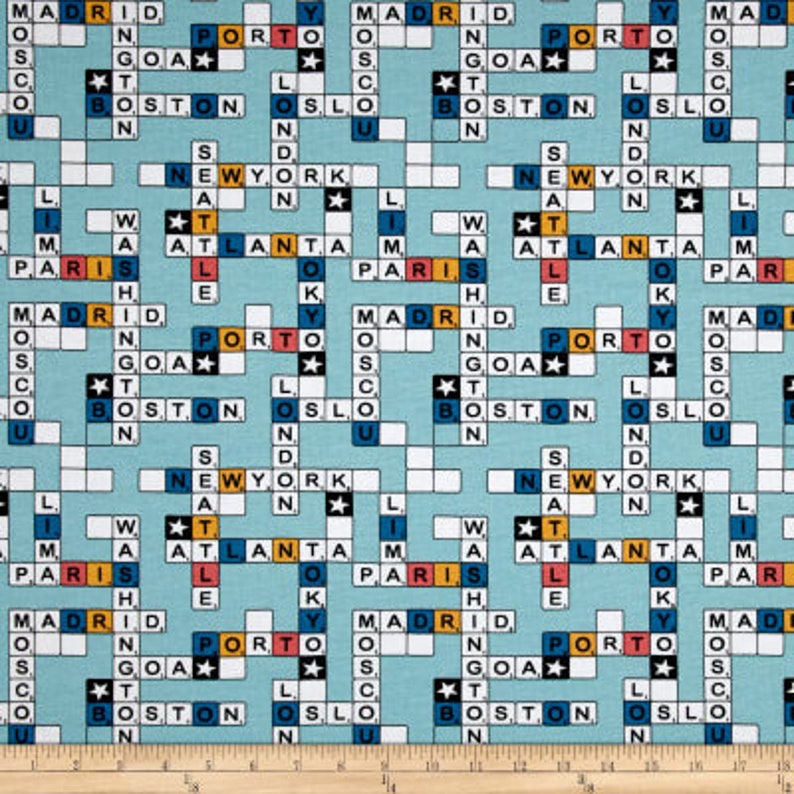 May include: Light blue fabric with a crossword puzzle design featuring city names like New York, Paris, and Madrid. The crossword squares are white with black letters, and the city names are in various colors. The fabric is suitable for quilting or crafting.