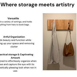 May include: A wooden wall-mounted coat rack with a light brown finish. The rack has multiple hooks and is holding a light gray jacket and a brown leather bag.