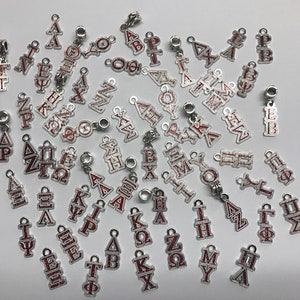 May include: A collection of silver charms with red Greek letters. The charms are designed for use on bracelets or necklaces.