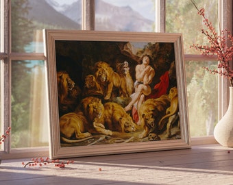 May include: A framed oil painting depicting a man sitting amongst a group of lions in a cave. The man is wearing a red cloth around his waist and has a worried expression on his face. The painting is set against a dark background with a hint of green foliage.