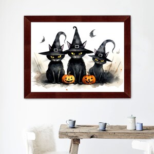 K&ouml;nnte beinhalten: Drei schwarze Katzen mit Hexenh&uuml;ten und orangefarbenen K&uuml;rbissen. Ein Aquarellbild mit Halloween-Motiven.