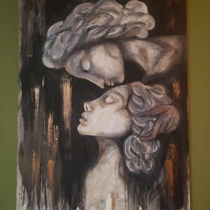 以下が含まれることがあります： 2 人の顔が寄り添う絵画。人物は灰色と白のグラデーションで描かれており、背景は金色がかった黒である。