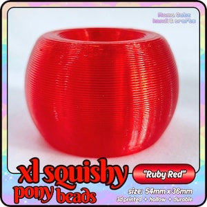 Puede incluir: Una cuenta XL squishy de color rojo rubí, impresa en 3D, hueca y duradera. La cuenta tiene forma redondeada con una superficie texturizada y una abertura central. Mide 5,4 cm x 3,6 cm. El texto en la imagen dice "Ruby Red".
