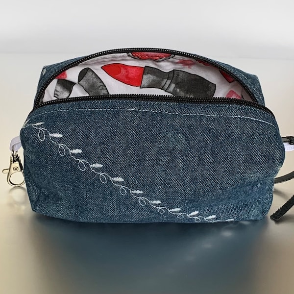 Embroidered distressed denim makeup bag