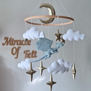 Móvil de bebé con dragón volador de fieltro, estrellas doradas y luna. Decoración colgante de fantasía para habitación infantil. imagen 1