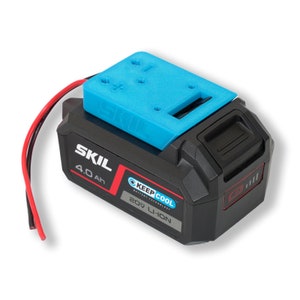 Peut inclure: Une batterie SKIL 20V Li-Ion noire et bleue d'une capacité de 4,0 Ah. La batterie est dotée d'un couvercle en plastique bleu avec une fente pour un accessoire d'outil. La batterie est munie d'une étiquette rouge avec le texte "KEEP COOL" et "BATTERY TECHNOLOGY".
