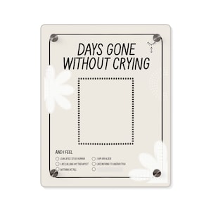Pode incluir: Um quadro branco de apagamento a seco com moldura preta e pinos de pressão prateados. O quadro tem o texto "Days Gone Without Crying" e um espaço para acompanhar o número de dias. Abaixo do espaço, há uma lista de opções para descrever como a pessoa se sente: "Qualified to be human", "Like calling my therapist", "Nothing at all", "I am an alien", e "Like moving to Antarctica".