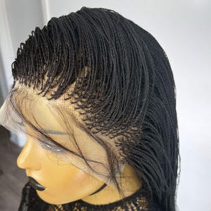 May include: A black lace front wig with micro braids. The wig is styled in a long, straight style.