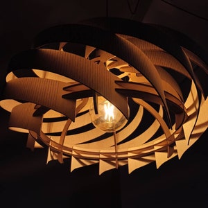 May include: A wooden pendant light fixture with a spiral design and a warm white light bulb. The light fixture is made of multiple layers of wood that are stacked on top of each other to create a spiral shape.