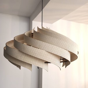 May include: A modern, wooden pendant light fixture with a unique, swirling design. The light is made of multiple layers of thin, light wood, creating a layered effect. The wood has a natural, light brown color.