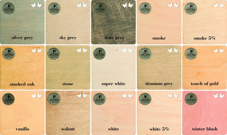 May include: A selection of wooden squares in shades like silver grey, sky grey, and slate grey, each with a colour name and a logo featuring butterflies. The colour range includes 'smoke' and 'winter blush'. Measurements are not applicable.