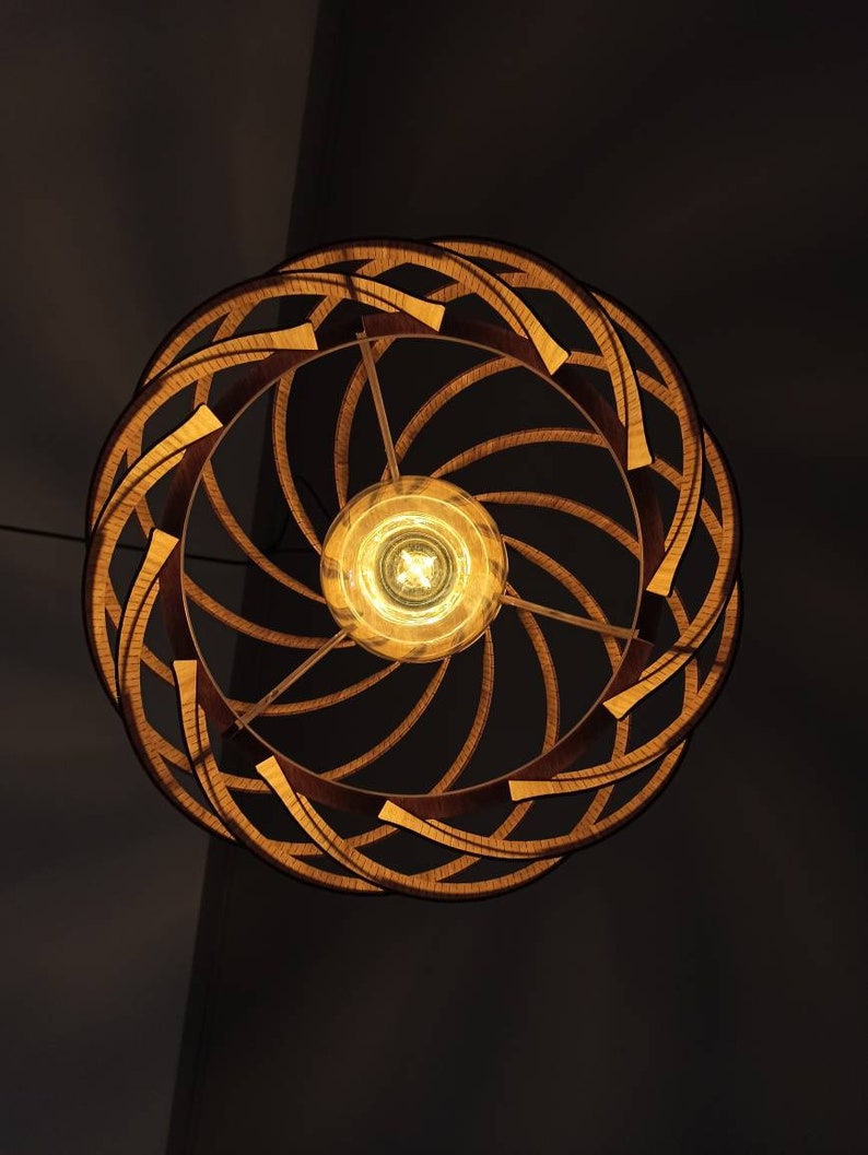 Może przedstawiać: Drewniana lampa sufitowa o spiralnym wzorze z ciepłą żar&oacute;wką. Lampa wykonana jest z naturalnego drewna i ma rustykalny wygląd.