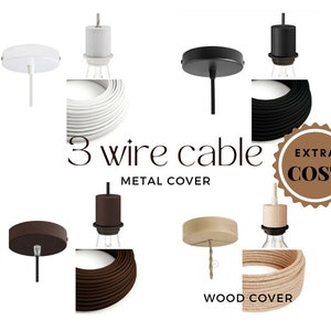 May include: A selection of ceiling light fixture canopy covers in white, black, brown, and natural wood. The covers are shown with matching cord colours. The text "3 wire cable" and "metal cover" is displayed below the image. The text "extra cost" is displayed in a brown circle with a starburst design.