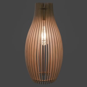 May include: A wooden pendant light fitting with a teardrop shape. The light is made of vertical wooden slats, allowing light to filter through. An Edison bulb is visible inside, casting a warm glow. The fitting is suspended from the ceiling.