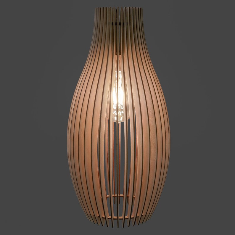May include: A wooden pendant light fitting with a teardrop shape. The light is made of vertical wooden slats, allowing light to filter through. An Edison bulb is visible inside, casting a warm glow. The fitting is suspended from the ceiling.