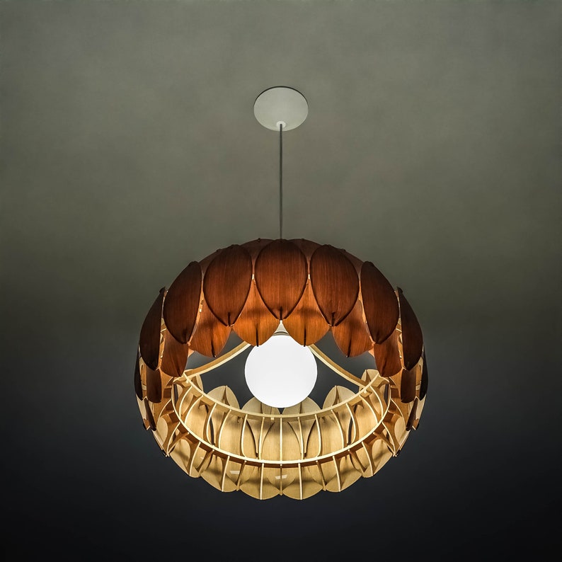 May include: A wooden pendant light fixture with a circular design and a white light bulb. The fixture is made up of many individual wooden pieces that resemble leaves.