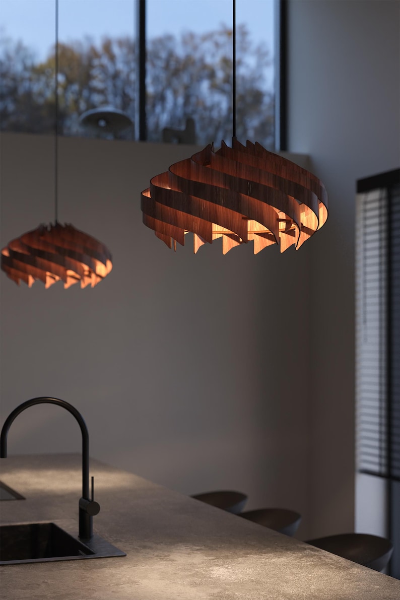 May include: Two wooden pendant lights with a spiral design hang from the ceiling. The lights are made of thin, curved wooden slats that create a layered effect. The warm light from the bulbs inside illuminates the wood, creating a cozy atmosphere.
