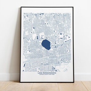May include: A blue and white map print of Lake Ronkonkoma, Suffolk County, New York. The map shows the streets and roads of the area, as well as the lake itself.