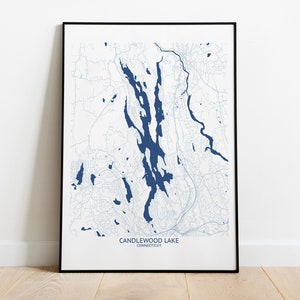 May include: A black framed print of a map of Candlewood Lake in Connecticut. The lake is shown in blue, with surrounding roads and towns in light gray.
