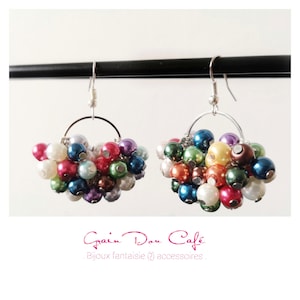 May include: A pair of colourful beaded earrings with silver hoops. The beads are a mix of white, pink, red, green, blue, and purple.